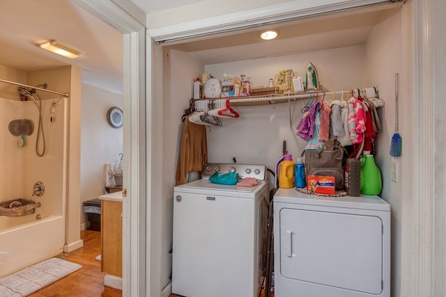 laundry area with light hardwood / wood-style floors and washer and dryer