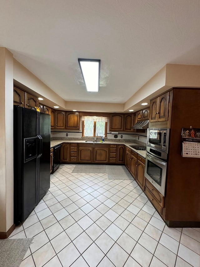 1595 Edgewater Dr, Grundy, VA 24614 - kitchen featuring black appliances, under cabinet range hood, light countertops, and light tile patterned floors