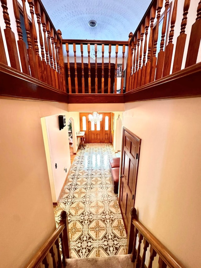 1595 Edgewater Dr, Grundy, VA 24614 - staircase with a high ceiling, a chandelier, and baseboards