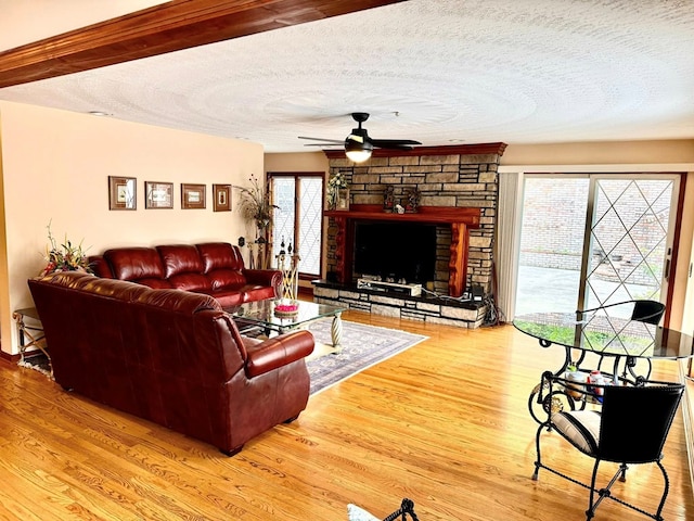 1595 Edgewater Dr, Grundy, VA 24614 - living area with a ceiling fan, wood finished floors, a textured ceiling, and a stone fireplace