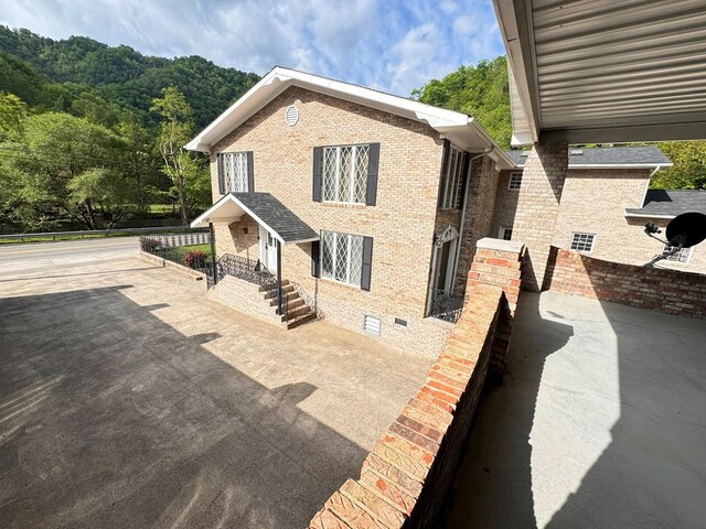 1595 Edgewater Dr, Grundy, VA 24614 - rear view of house featuring brick siding, crawl space, and a view of trees