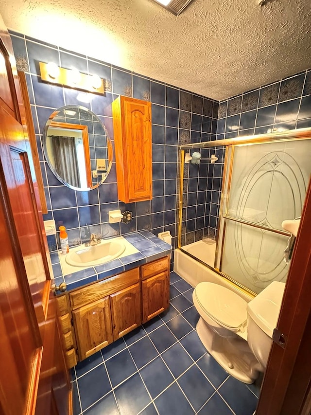 1595 Edgewater Dr, Grundy, VA 24614 - full bath with tile patterned floors, toilet, a textured ceiling, tile walls, and vanity