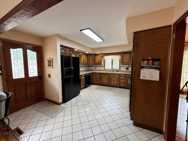 1595 Edgewater Dr, Grundy, VA 24614 - kitchen featuring black appliances, a sink, light countertops, light tile patterned floors, and brown cabinets