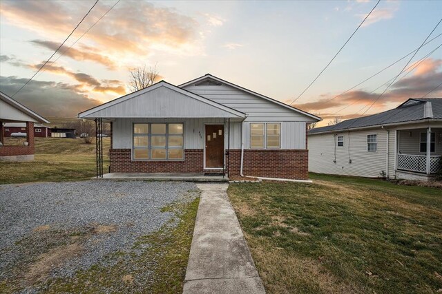 409 Crescent Dr, Glade Spring, VA 24340 - bungalow-style house with brick siding, a yard, board and batten siding, and covered porch