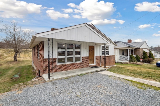 409 Crescent Dr, Glade Spring, VA 24340 - bungalow with brick siding, a porch, a front lawn, and board and batten siding