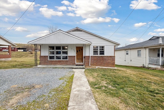 409 Crescent Dr, Glade Spring, VA 24340 - bungalow-style home featuring brick siding, a front lawn, a porch, board and batten siding, and gravel driveway