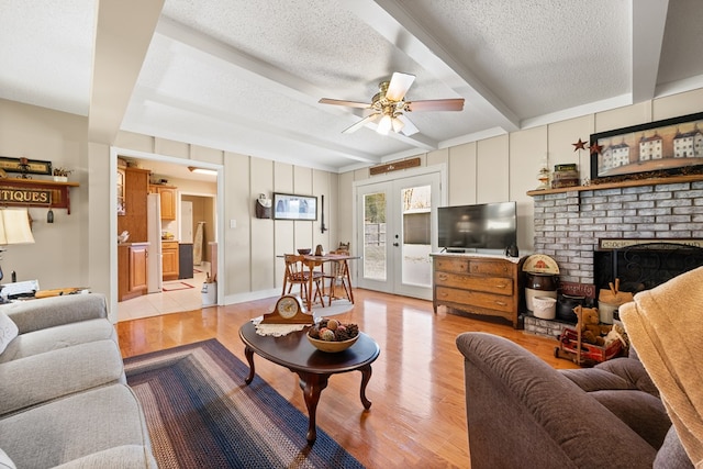 7268 Southern View Rd, Bristol, VA 24202 - living area with beam ceiling, a textured ceiling, ceiling fan, light wood-style flooring, and a brick fireplace