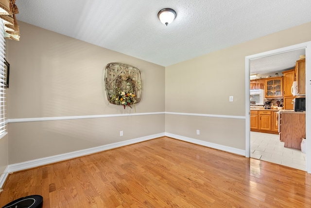 7268 Southern View Rd, Bristol, VA 24202 - empty room with baseboards, light wood-type flooring, and a textured ceiling