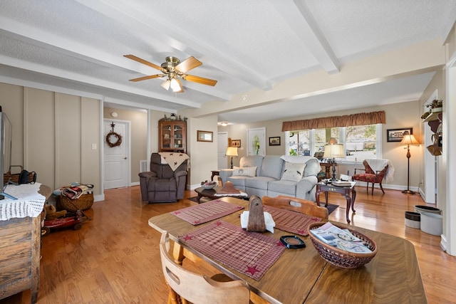 7268 Southern View Rd, Bristol, VA 24202 - living room with a ceiling fan, a textured ceiling, baseboards, beamed ceiling, and light wood-style floors