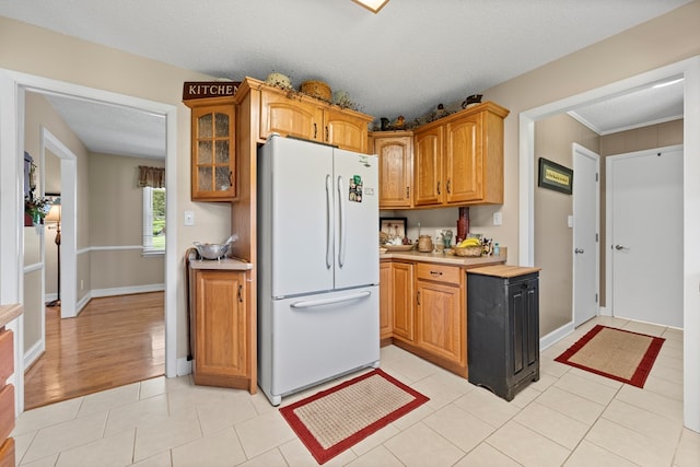 7268 Southern View Rd, Bristol, VA 24202 - kitchen featuring glass insert cabinets, freestanding refrigerator, baseboards, light countertops, and light tile patterned flooring