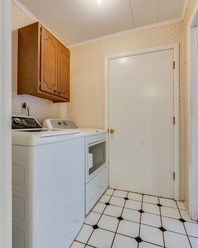 washroom featuring washer and clothes dryer, light floors, cabinet space, ornamental molding, and wallpapered walls