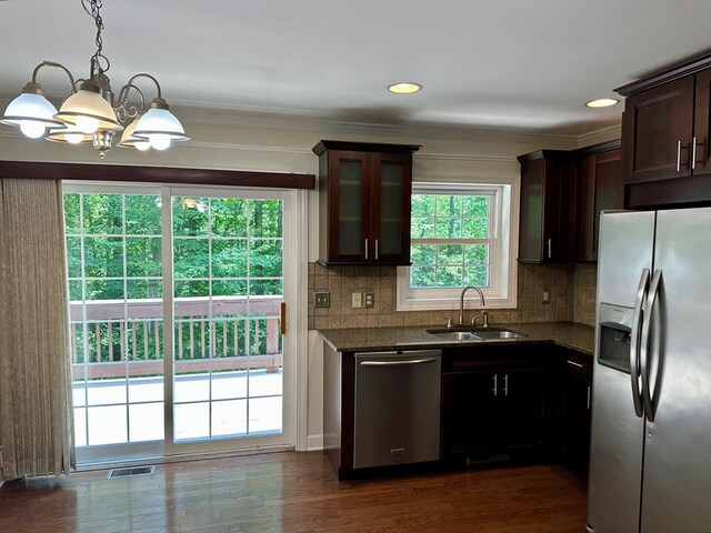 23677 Archery Range Rd, Bristol, VA 24202 - kitchen with stainless steel appliances, a chandelier, decorative backsplash, dark brown cabinetry, and glass insert cabinets