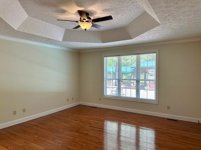 23677 Archery Range Rd, Bristol, VA 24202 - empty room with a textured ceiling, wood finished floors, a ceiling fan, ornamental molding, and a tray ceiling