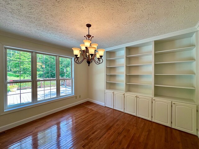 23677 Archery Range Rd, Bristol, VA 24202 - spare room featuring a textured ceiling, a chandelier, crown molding, dark wood-style floors, and built in shelves