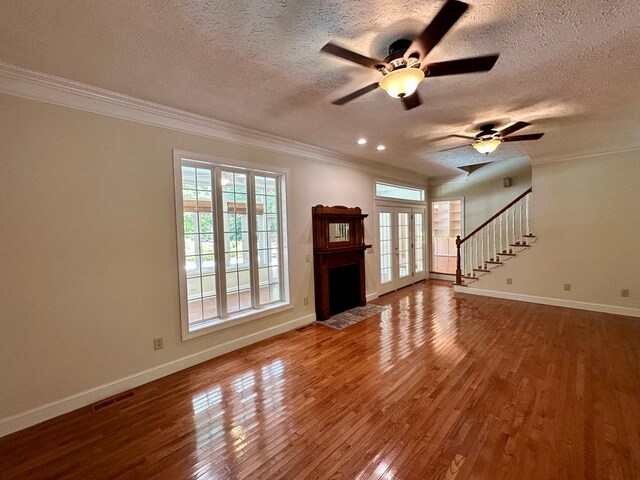 23677 Archery Range Rd, Bristol, VA 24202 - unfurnished living room featuring ornamental molding, wood finished floors, a ceiling fan, stairway, and a fireplace with flush hearth