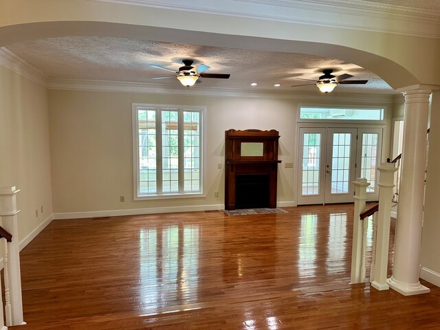 23677 Archery Range Rd, Bristol, VA 24202 - unfurnished living room featuring ceiling fan, arched walkways, wood finished floors, a fireplace with flush hearth, and a textured ceiling