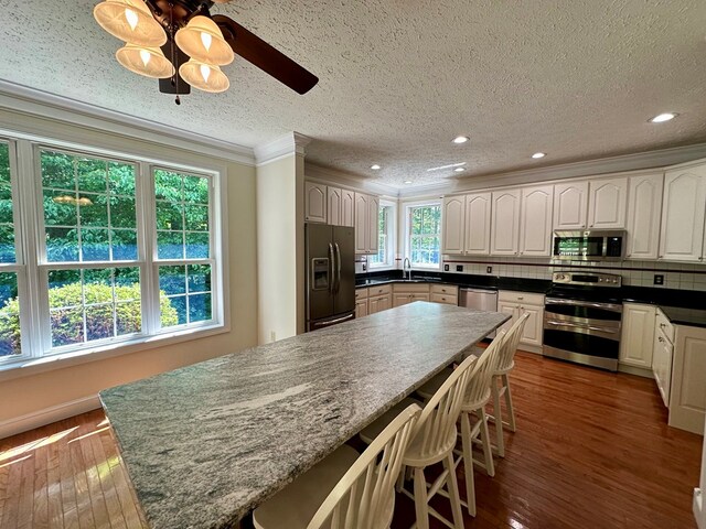 23677 Archery Range Rd, Bristol, VA 24202 - kitchen with appliances with stainless steel finishes, ornamental molding, dark wood-style floors, backsplash, and a textured ceiling