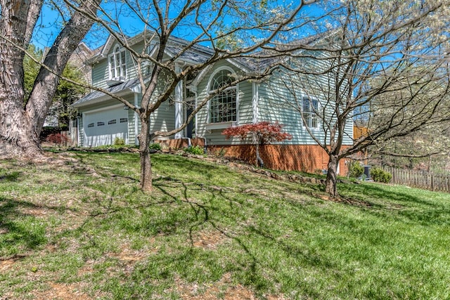 view of front of home with fence, a front yard, and a garage