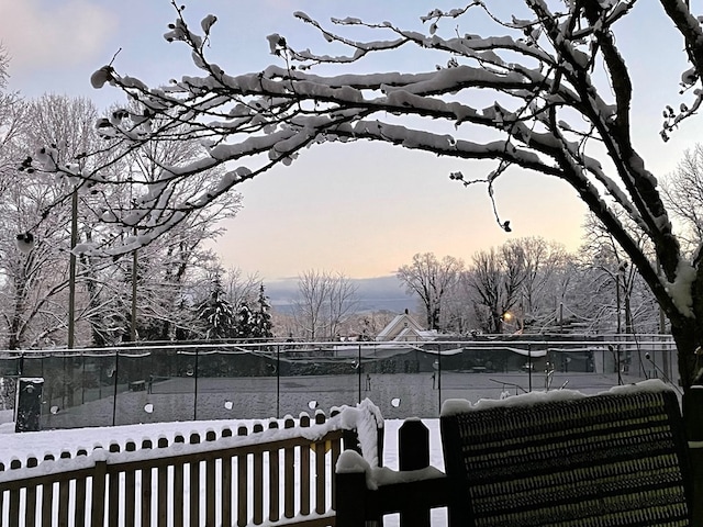 view of yard with fence and a tennis court