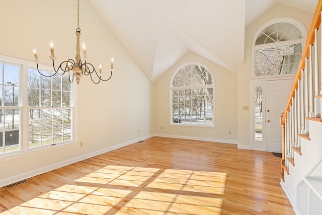 foyer featuring light wood-style floors, stairs, a notable chandelier, and visible vents