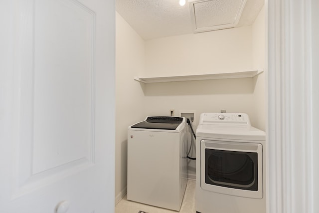 clothes washing area featuring separate washer and dryer and a textured ceiling