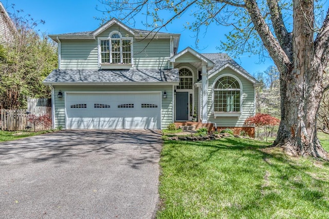 view of front facade with a garage, a front lawn, fence, roof with shingles, and driveway
