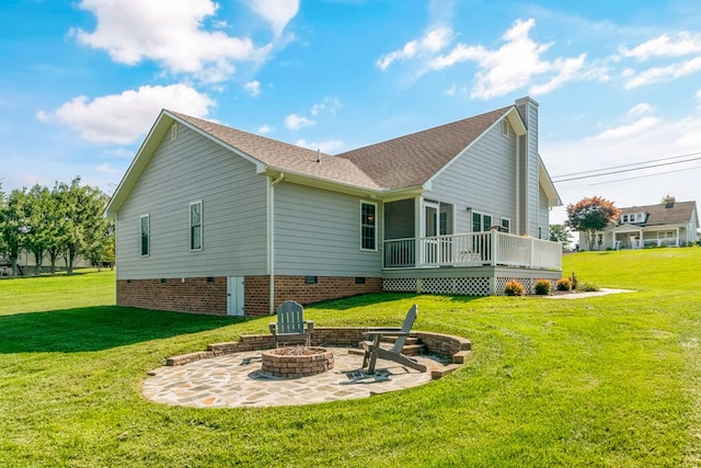 back of house featuring a patio area, a yard, a deck, and a fire pit