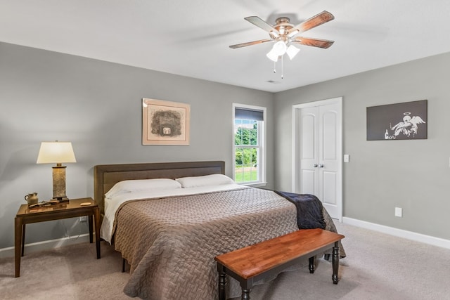 carpeted bedroom with ceiling fan and a closet