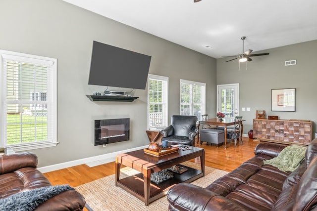 living room with light hardwood / wood-style flooring and ceiling fan