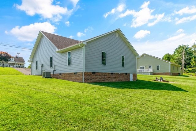 back of property featuring central AC and a lawn