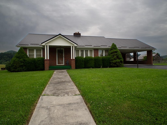3878 Blue Grass Trl, Saltville, VA 24370 - view of front of home featuring brick siding, a chimney, a front yard, and a metal roof
