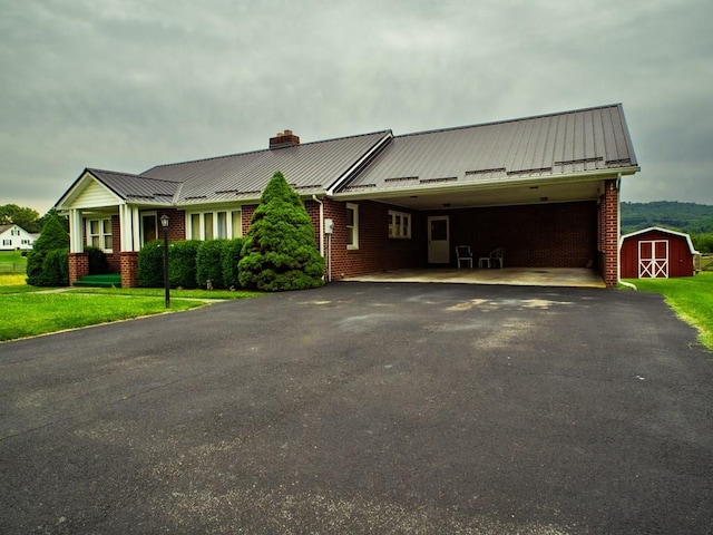 3878 Blue Grass Trl, Saltville, VA 24370 - view of front of home featuring a shed, driveway, brick siding, a chimney, and a carport