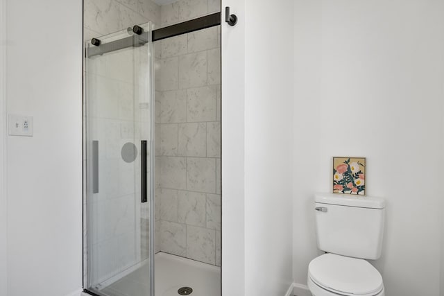 full bathroom with baseboards, a stall shower, and toilet