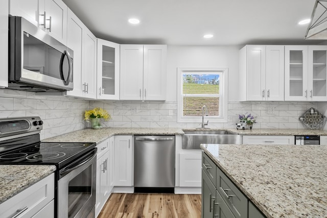 kitchen featuring appliances with stainless steel finishes, a sink, white cabinetry, and recessed lighting
