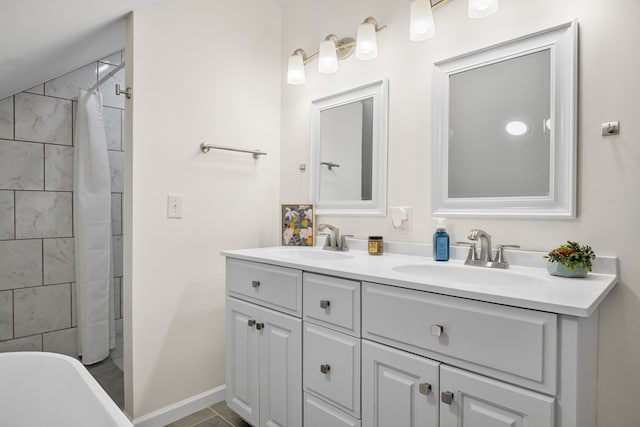bathroom with double vanity, a freestanding tub, a shower with shower curtain, and baseboards