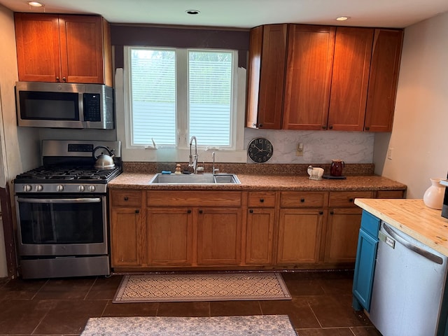 108 Square St, Bluefield, VA 24605 - kitchen featuring appliances with stainless steel finishes, a sink, dark tile patterned floors, brown cabinetry, and recessed lighting