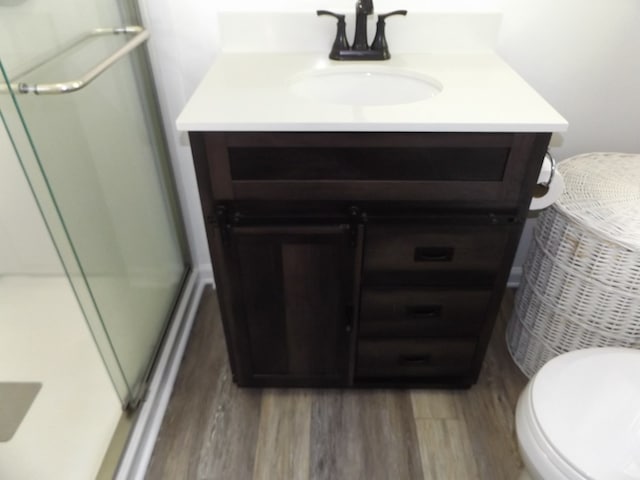304 Edgewood Dr, Galax, VA 24333 - bathroom featuring wood finished floors, a shower with door, vanity, and toilet