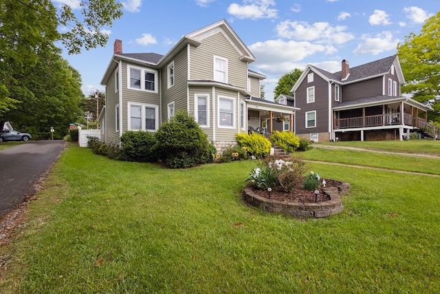 88 W Banner St, Lebanon, VA 24266 - view of front of home with a chimney, a front lawn, and covered porch