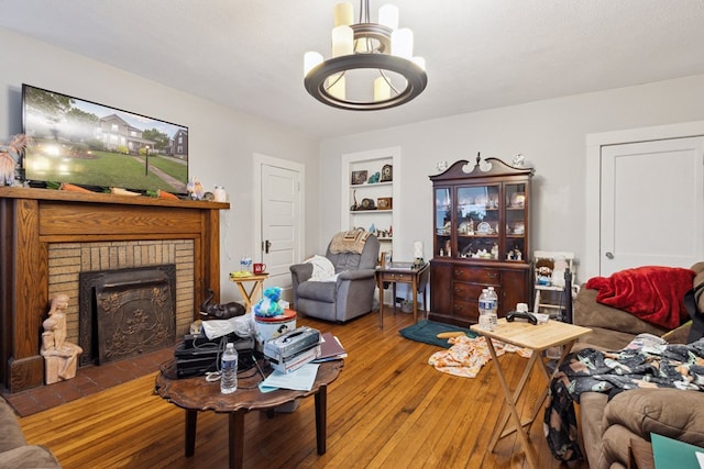 88 W Banner St, Lebanon, VA 24266 - living area with hardwood / wood-style flooring, a chandelier, built in shelves, and a fireplace