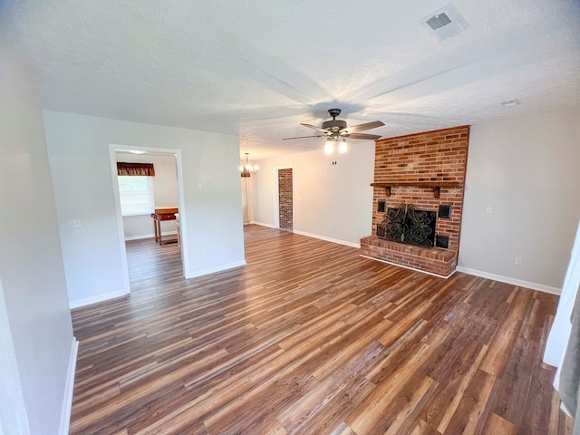123 Clearwater Ln, Galax, VA 24333 - unfurnished living room featuring ceiling fan, wood finished floors, a fireplace, a textured ceiling, and a chandelier