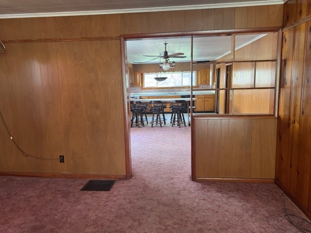14091 Rocket Boys Dr, War, WV 24892 - unfurnished dining area with carpet, wood walls, and ceiling fan