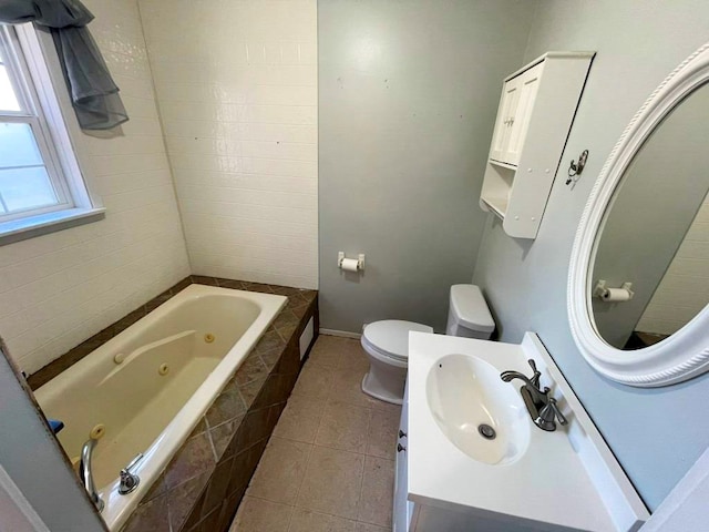 bathroom featuring toilet, tile patterned floors, tiled bath, and vanity