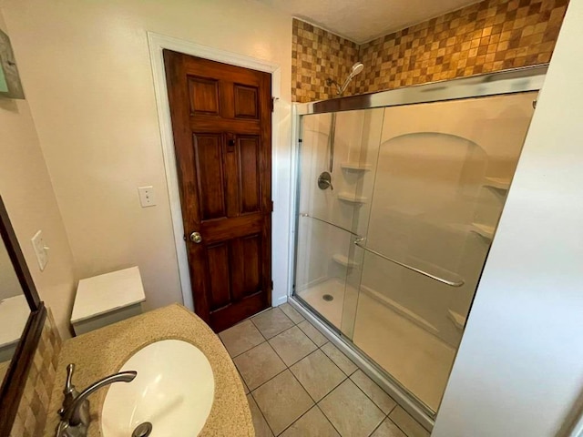 bathroom with tile patterned flooring, sink, and a shower with shower door