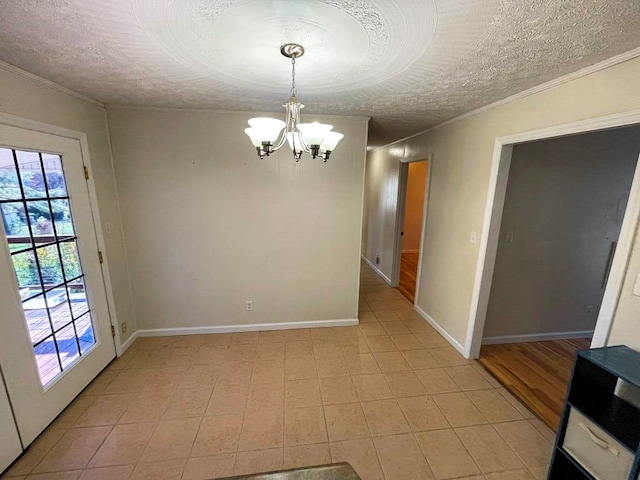 unfurnished dining area featuring ornamental molding, a textured ceiling, and a notable chandelier