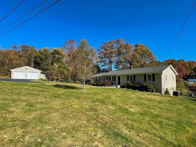 view of front of home featuring an outbuilding, cooling unit, a garage, and a front lawn