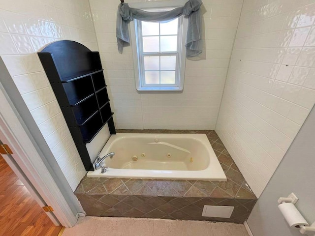 bathroom featuring a relaxing tiled tub and tile patterned floors