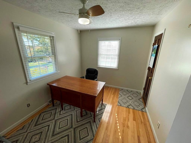 home office with hardwood / wood-style floors, a textured ceiling, and ceiling fan