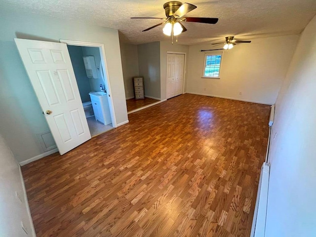 empty room with hardwood / wood-style flooring, a baseboard radiator, and a textured ceiling