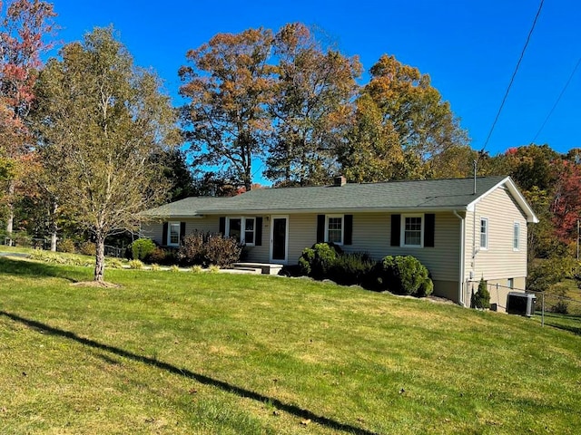 ranch-style home with cooling unit and a front lawn