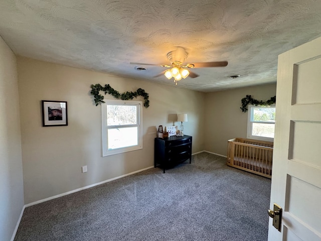 unfurnished bedroom with multiple windows, radiator, a textured ceiling, and carpet flooring